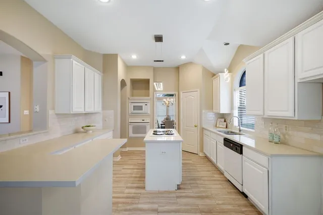 a large kitchen with stainless steel appliances a lot of counter space and wooden floors