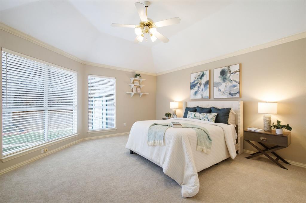 921 West Muirfield Road Garland, TX 75044 - Photo 19 of 33 a spacious bedroom with a bed a chandelier and large window