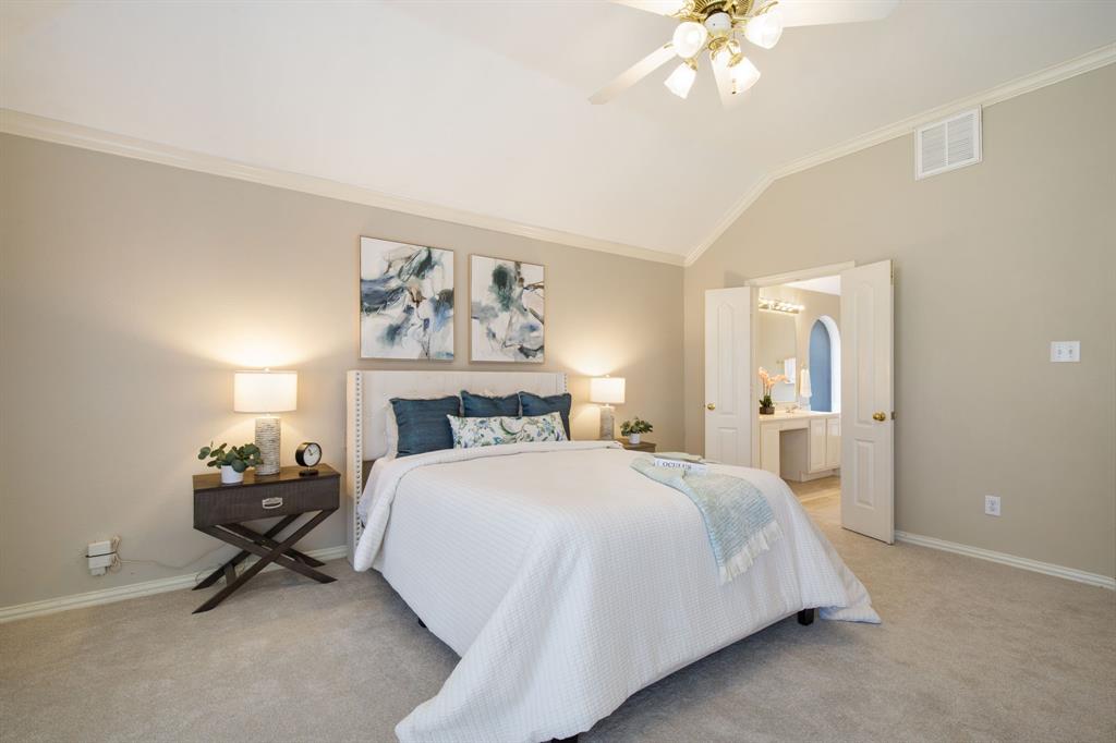 921 West Muirfield Road Garland, TX 75044 - Photo 20 of 33 a bedroom with a bed and a chandelier