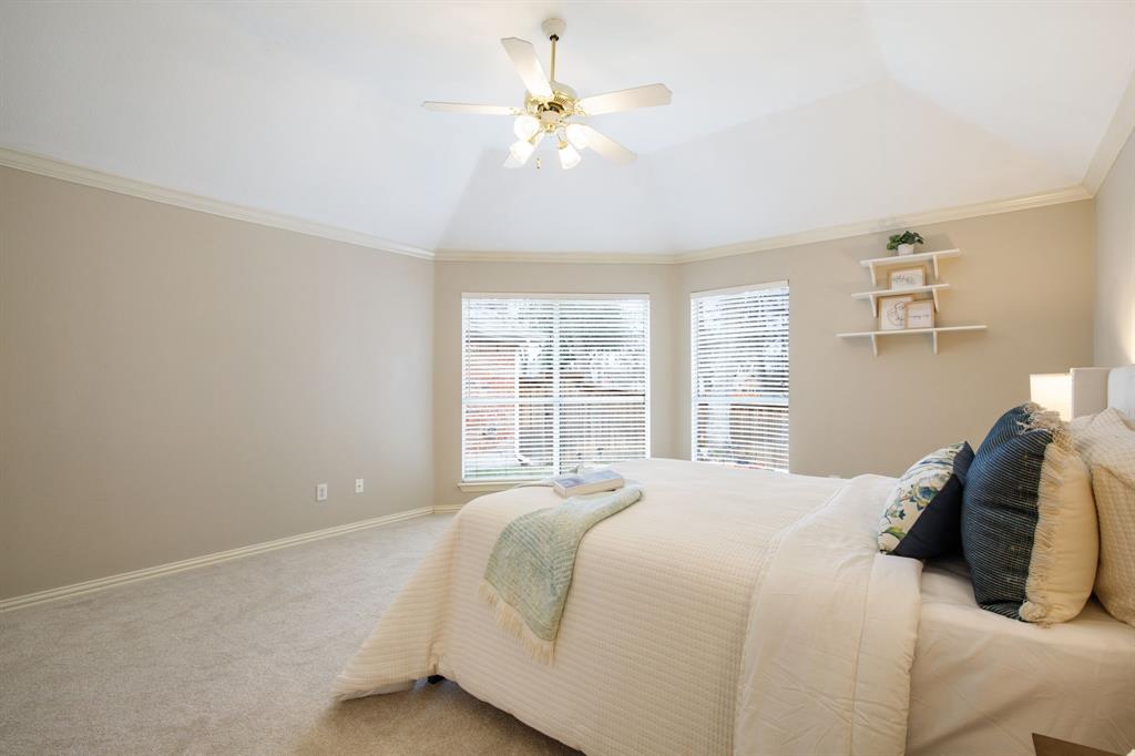 921 West Muirfield Road Garland, TX 75044 - Photo 21 of 33 a bedroom with a large bed and a chandelier