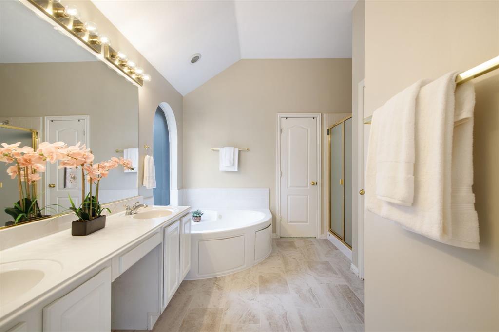921 West Muirfield Road Garland, TX 75044 - Photo 22 of 33 a bathroom with a white tub shower sink and mirror