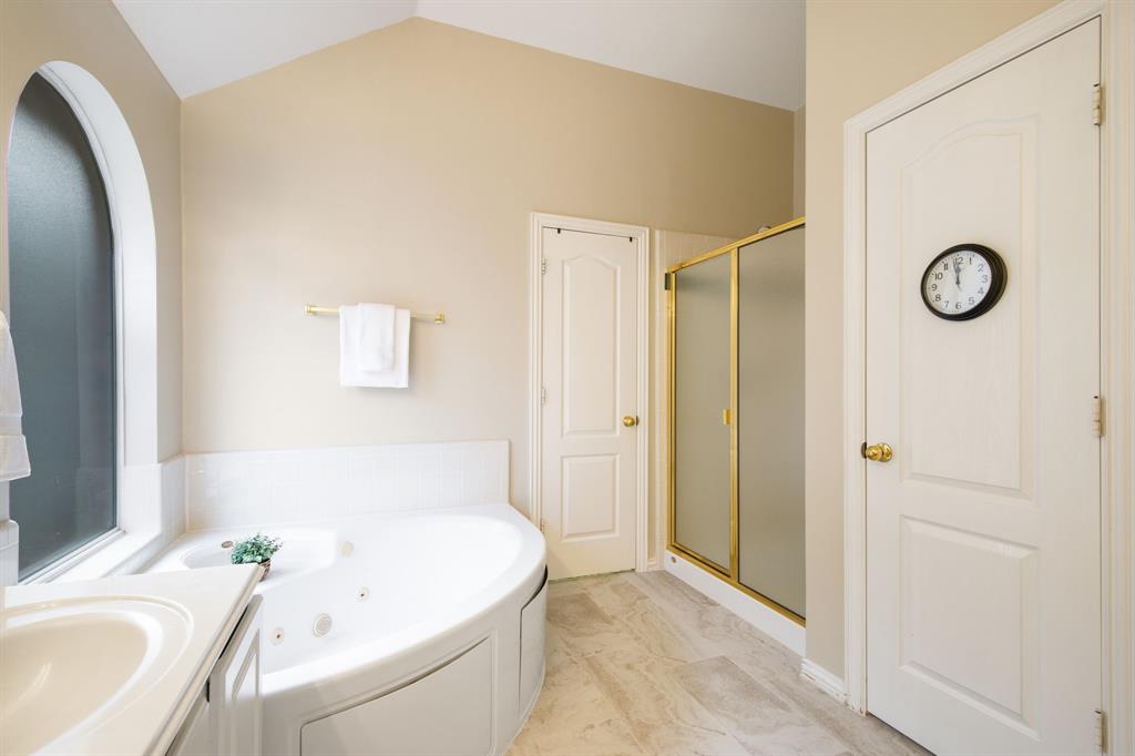 921 West Muirfield Road Garland, TX 75044 - Photo 24 of 33 a bathroom with a tub sink and mirror