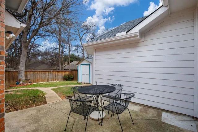 a backyard of a house with table and chairs
