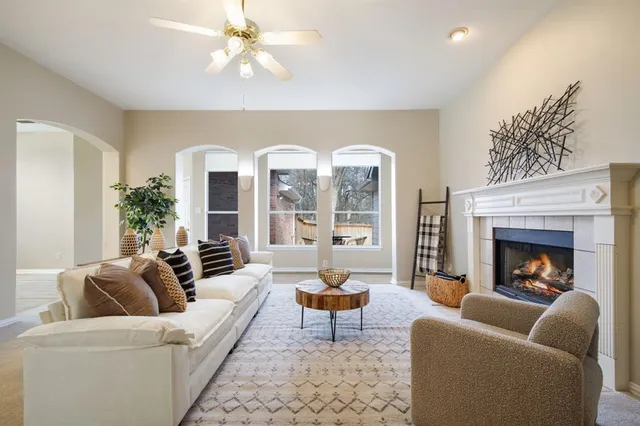 a living room with furniture fireplace and a large window