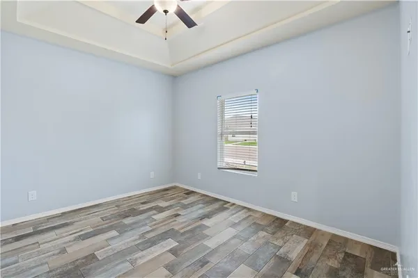 an empty room with a window and a ceiling fan