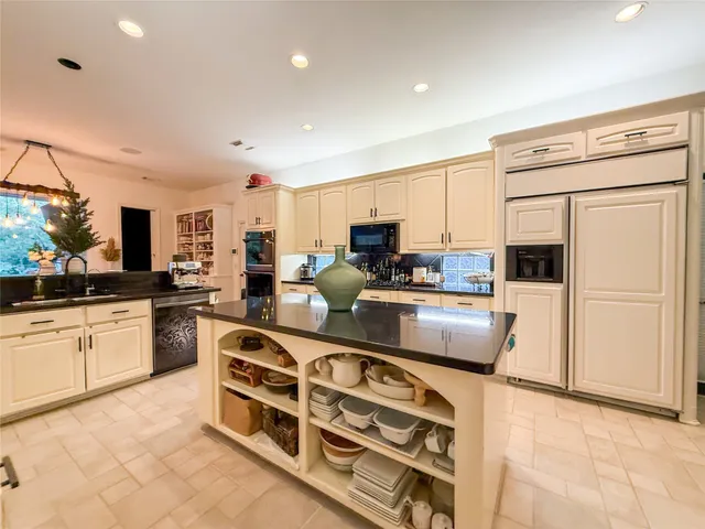 a kitchen with stainless steel appliances a stove top oven a sink a refrigerator white cabinets and wooden floor