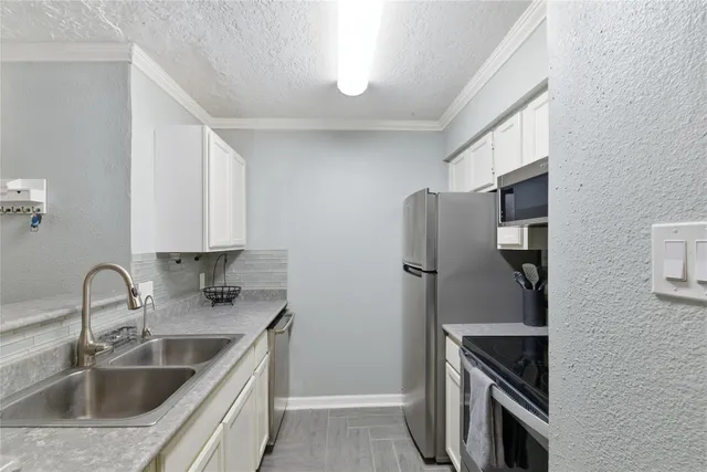 a kitchen with stainless steel appliances granite countertop a refrigerator and a sink