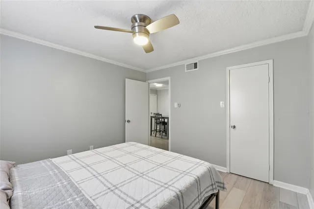 a bedroom with a large bed and a chandelier