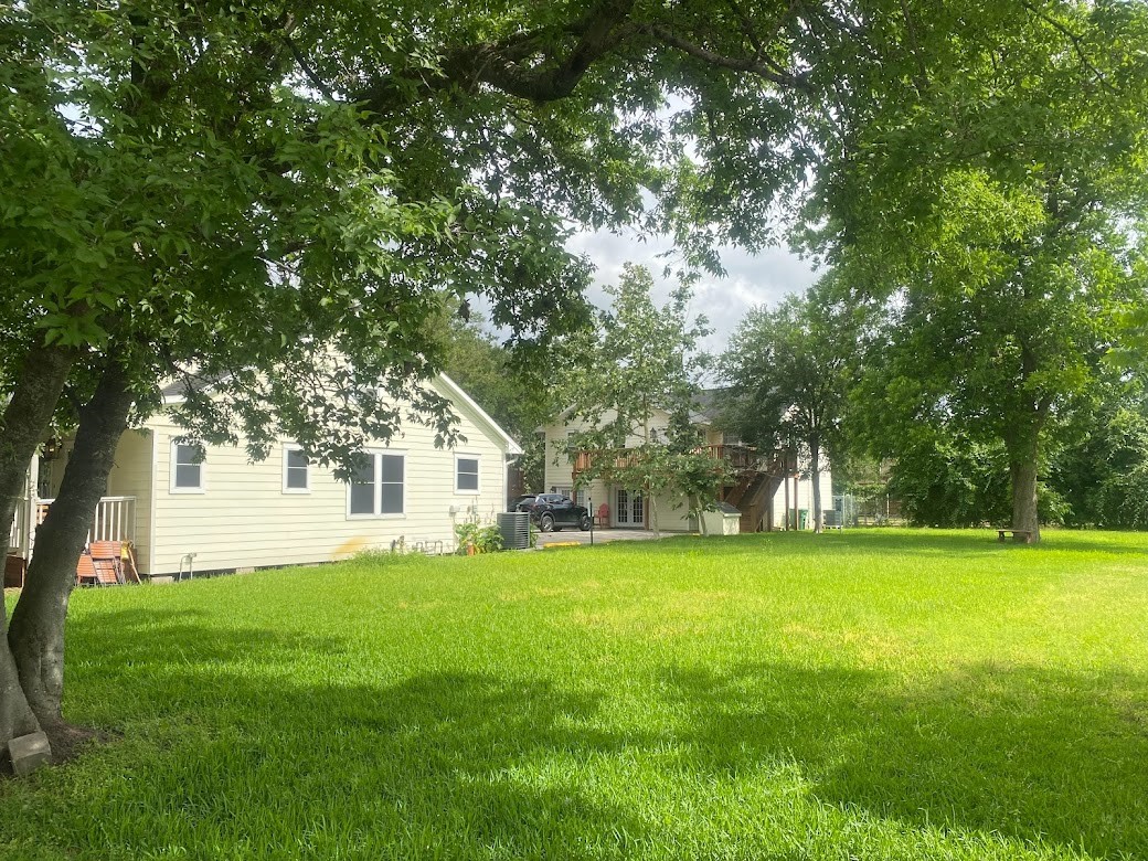 4918 Polk Street Houston, TX 77023 - Photo 3 of 3 a view of a house with a big yard and large trees