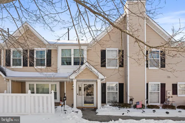 a view of a white house with large windows and a tree
