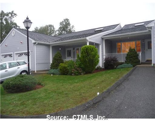 a view of a house with brick walls and a yard with plants