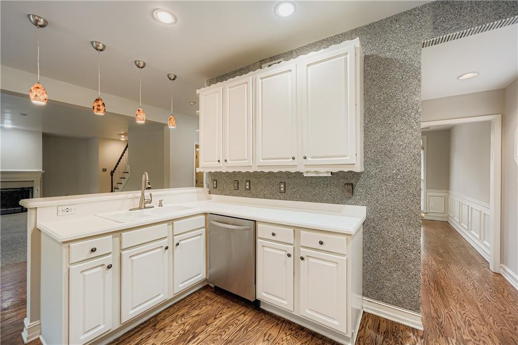 1581 Oak Park Cove Decatur, GA 30033 - Photo 11 of 32 a kitchen with a sink dishwasher and white cabinets with wooden floor