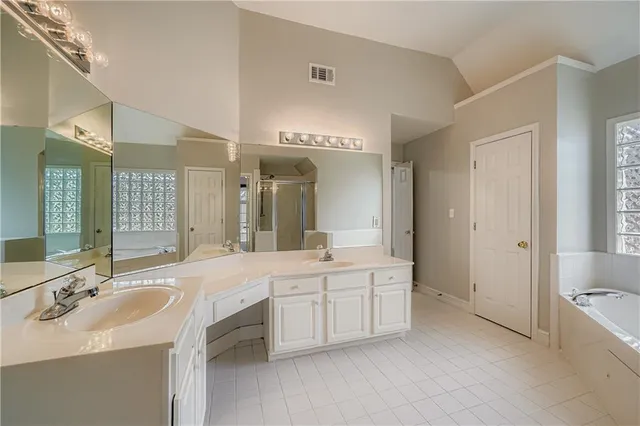 a large bathroom with a double vanity sink a large mirror and a bathtub
