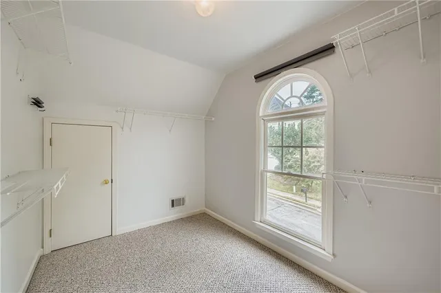 an empty room with windows and closet