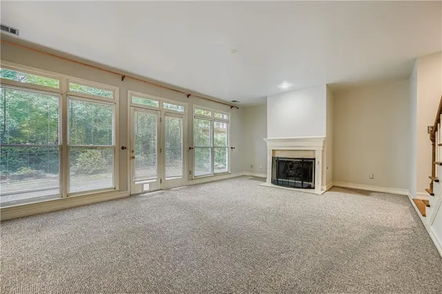 a view of an empty room with a fireplace and a window
