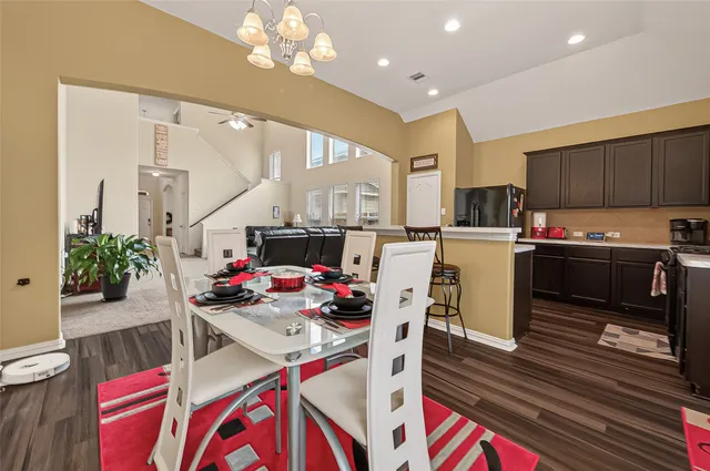 a open dining room with stainless steel appliances kitchen island granite countertop a dining table chairs kitchen view and living room view