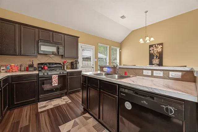 a kitchen with a sink appliances and cabinets