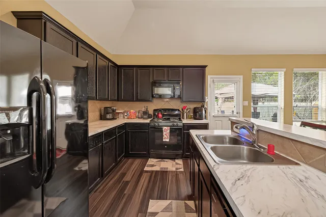 a kitchen with granite countertop a stove sink and cabinets