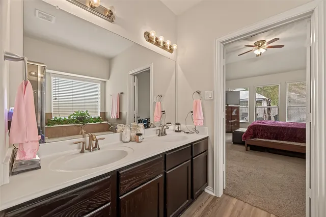 a en suite bathroom with a double vanity sink and a mirror