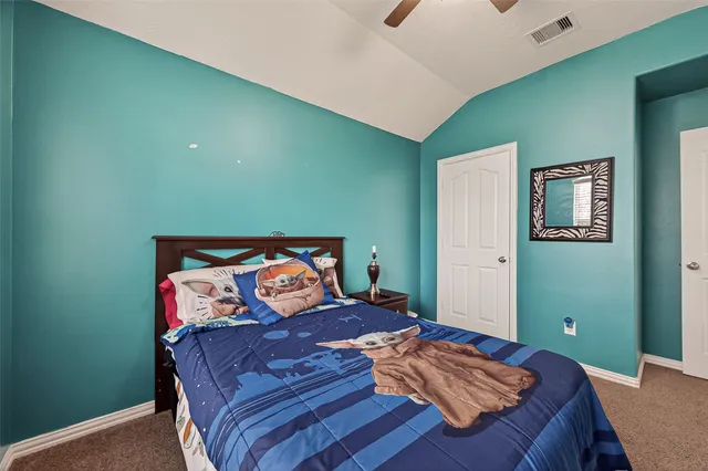 a bedroom with a bed and painting on the wall