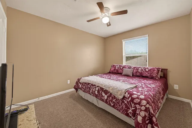 a bed sitting in a spacious bedroom next to a window