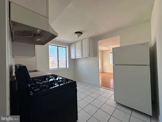 a kitchen with a refrigerator and a stove top oven