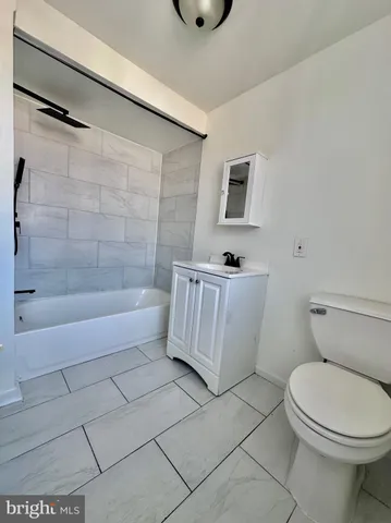 a bathroom with a toilet a sink a mirror and bathtub