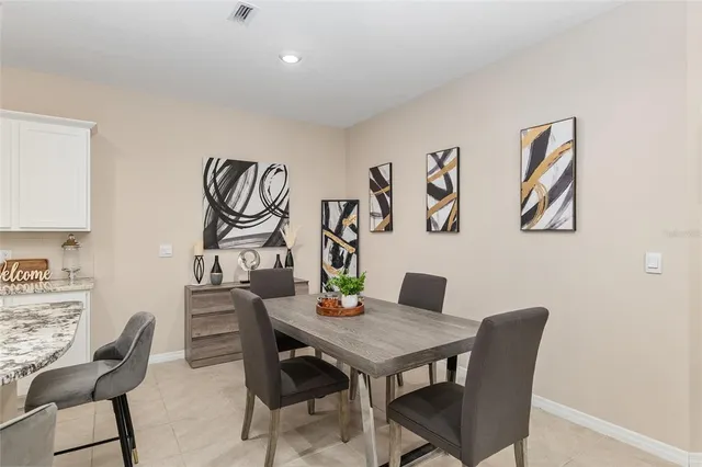 a kitchen with a dining table cabinets appliances and wooden floor