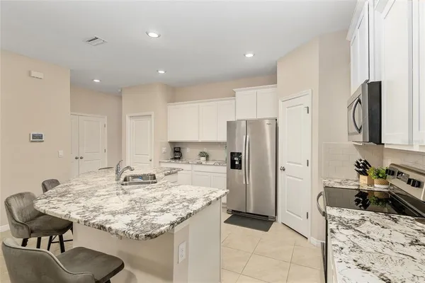a kitchen with stainless steel appliances white cabinets and a stove top oven