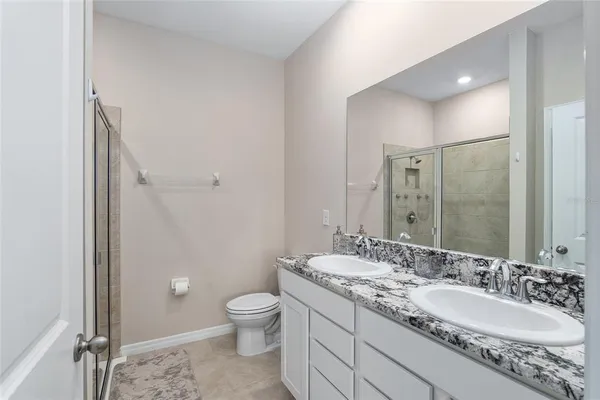 a en suite bathroom with a granite countertop tub and a sink