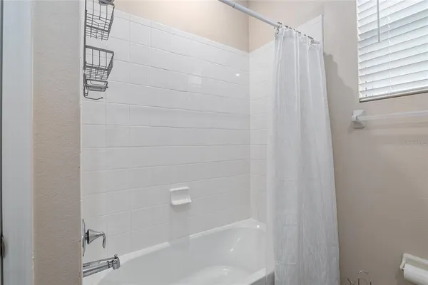 a bedroom with a bed and a lamp on dresser