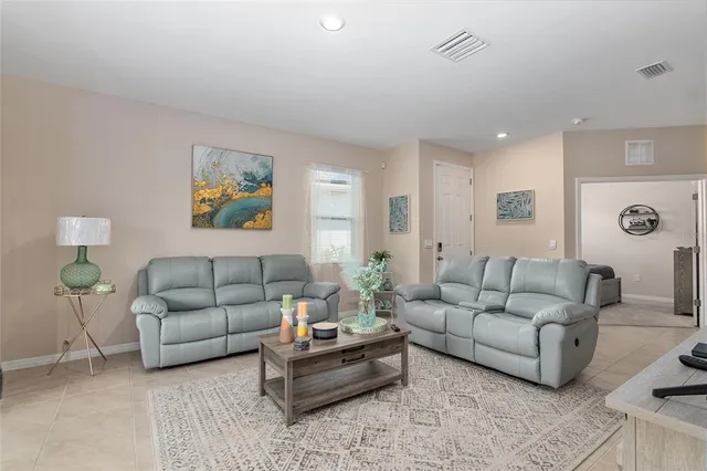 a living room with furniture and painting on the wall