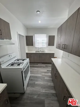 a kitchen with kitchen island stainless steel appliances a stove refrigerator and sink