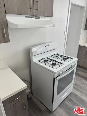 a white stove top oven sitting inside of a kitchen