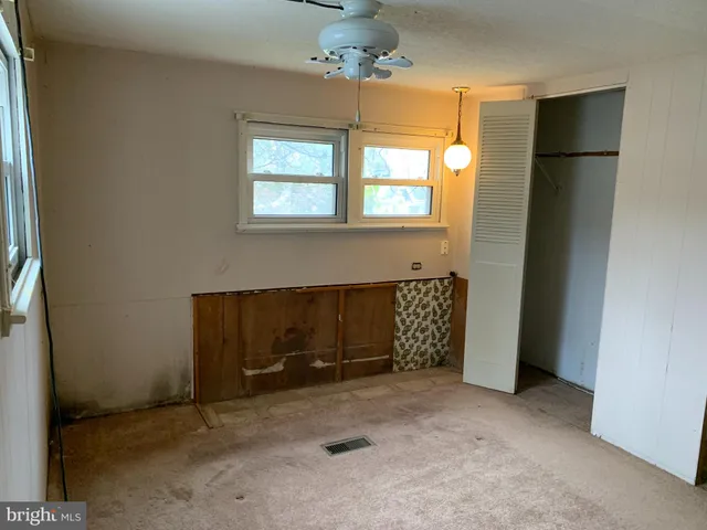 an empty room with windows and closet