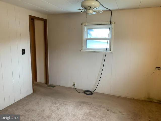 an empty room with chandelier fan