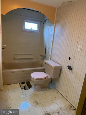 a bathroom with a granite countertop toilet and a bathtub