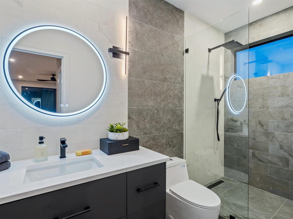 2467 Hyde Park Street Sarasota, FL 34239 - Photo 33 of 42 a bathroom with a sink a mirror a toilet and shower