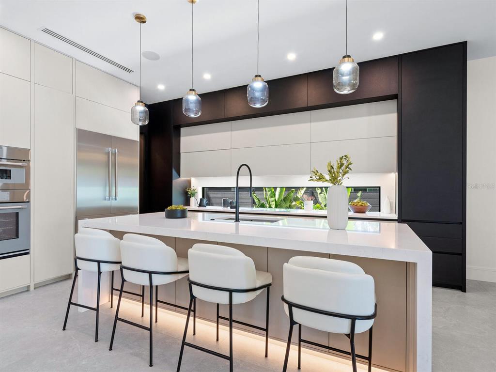 2467 Hyde Park Street Sarasota, FL 34239 - Photo 10 of 42 a kitchen with stainless steel appliances kitchen island granite countertop a table chairs and a refrigerator