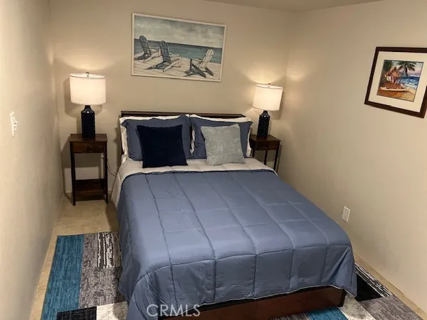 a bedroom with a bed and painting on the wall