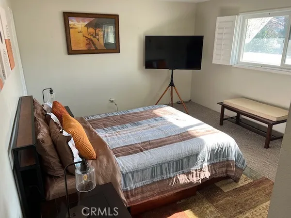 a bedroom with a bed and a flat screen tv