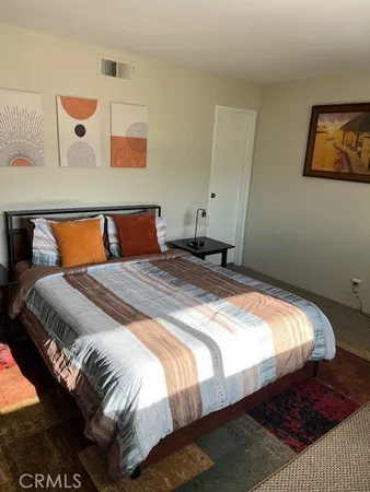 a bedroom with a bed and painting on the wall