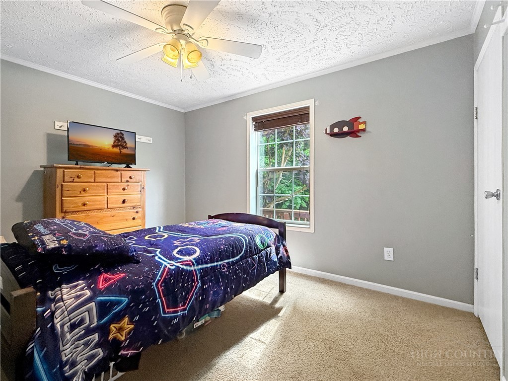 1173 Hopewell Church Road Boone, NC 28607 - Photo 19 of 39 a bedroom with a bed and a chandelier