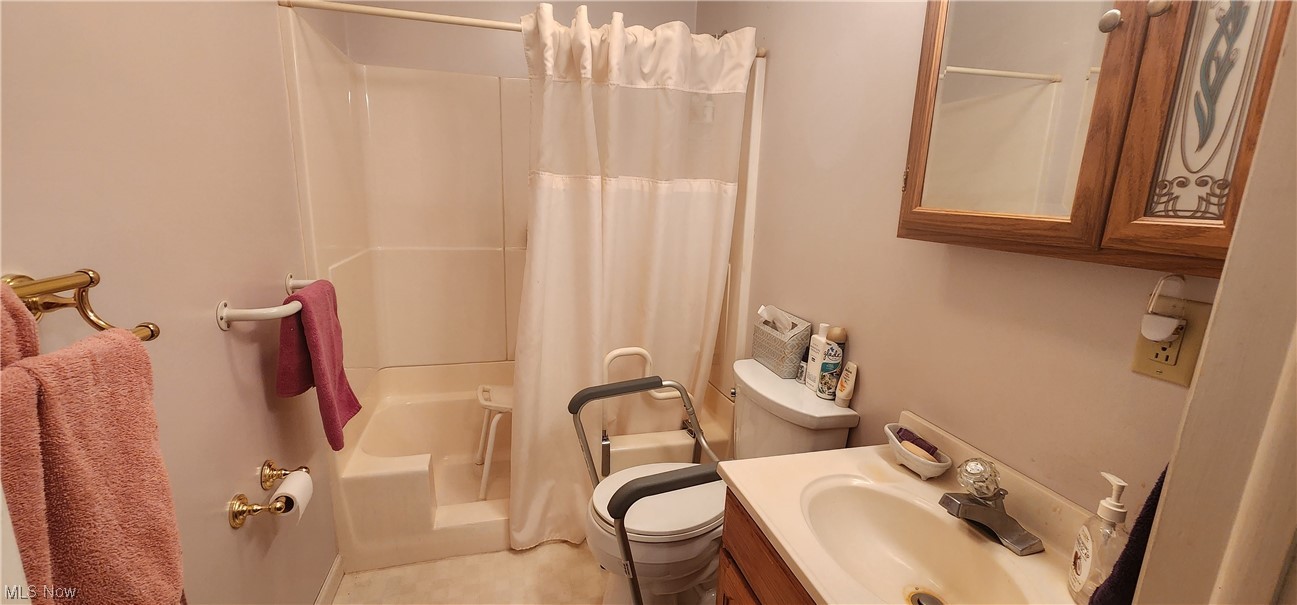 10966 Kile Road Chardon, OH 44024 - Photo 12 of 32 Full bathroom with shower / bath combo with shower curtain, mirror, large vanity, and light tile floors