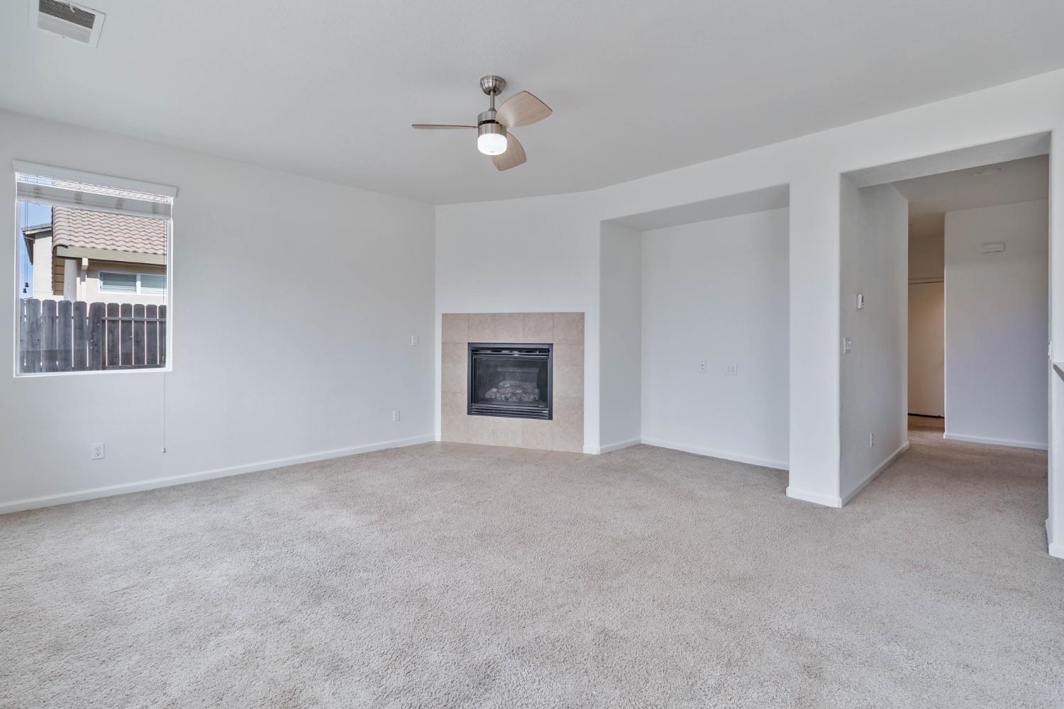 863 Chianti Circle Coalinga, CA 93210 - Photo 24 of 35 a view of an empty room with a fireplace and a window