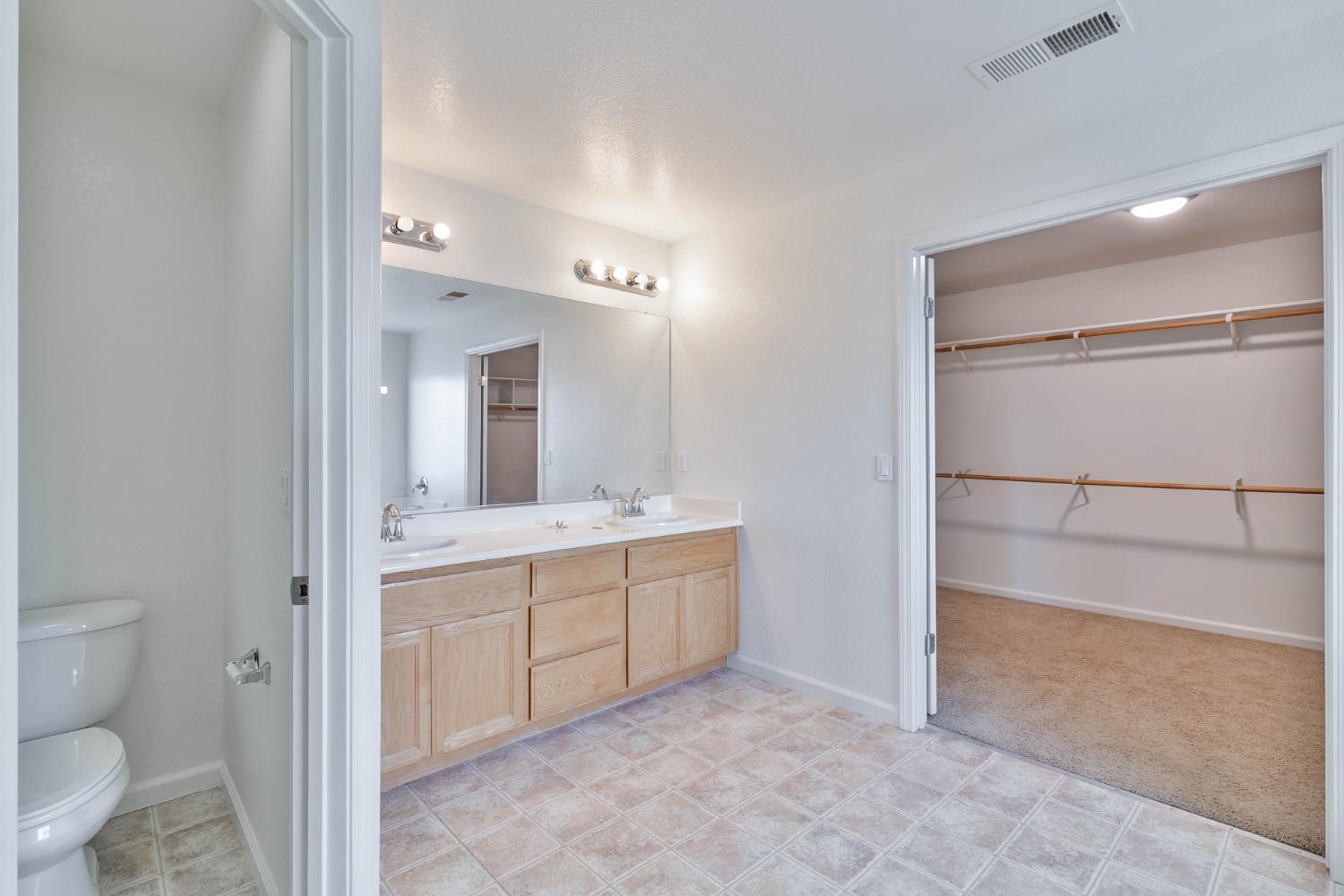 863 Chianti Circle Coalinga, CA 93210 - Photo 8 of 35 a spacious bathroom with a granite countertop sink a toilet mirror and vanity
