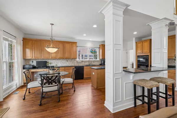 a kitchen with granite countertop wooden floors cabinets a dining table and chairs