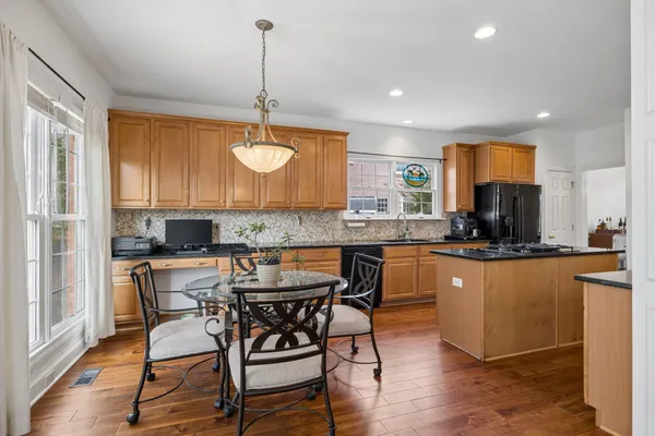 a kitchen with stainless steel appliances granite countertop a refrigerator a stove top oven a sink and dishwasher