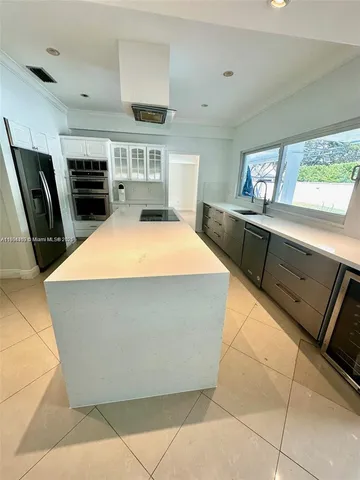 a large kitchen with a stove a refrigerator a sink and dishwasher