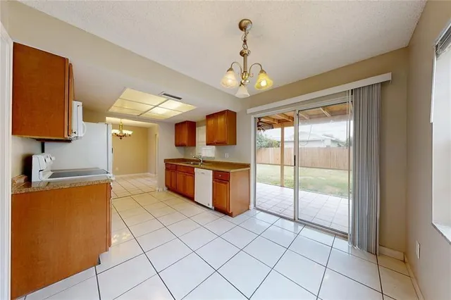 a large kitchen with stainless steel appliances granite countertop a stove a sink dishwasher and a view of living room